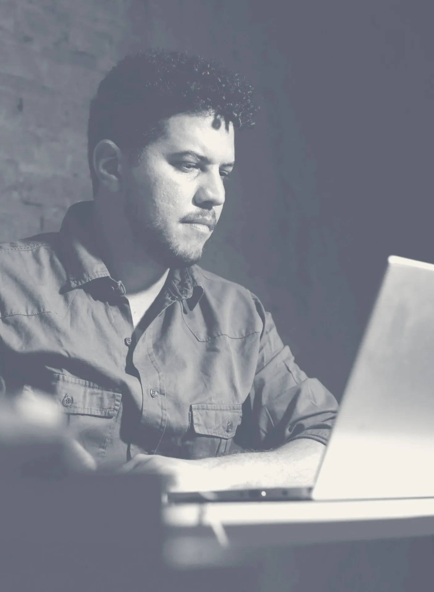 Marcus Vinícius concentrado, revisando um texto no notebook